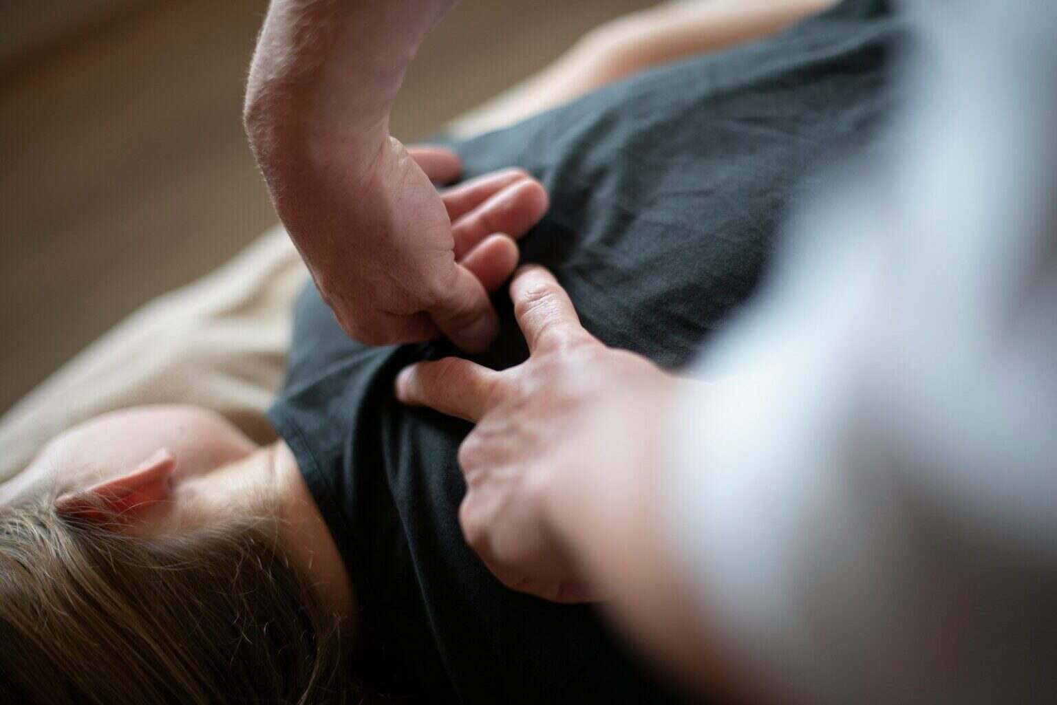 Massage : bien plus qu’un luxe, un outil de santé que vous sous-utilisez a woman laying on top of a bed holding a mans hand