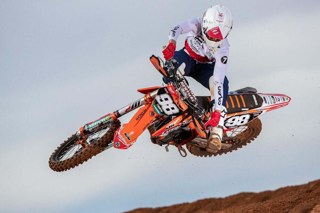 man in red and white motocross helmet riding motocross dirt bike