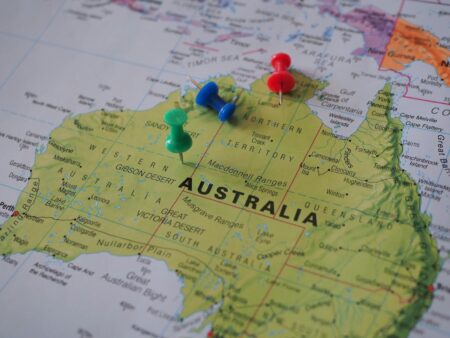 Close-up of a map of Australia featuring colorful pushpins marking locations.
