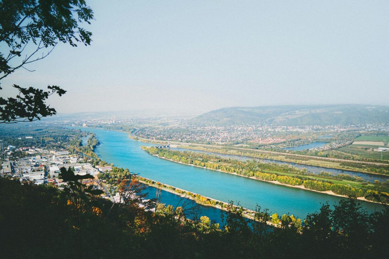 Scenic view of the Danube River from Kahlenberg Hill in Vienna, showcasing vibrant fall colors.
