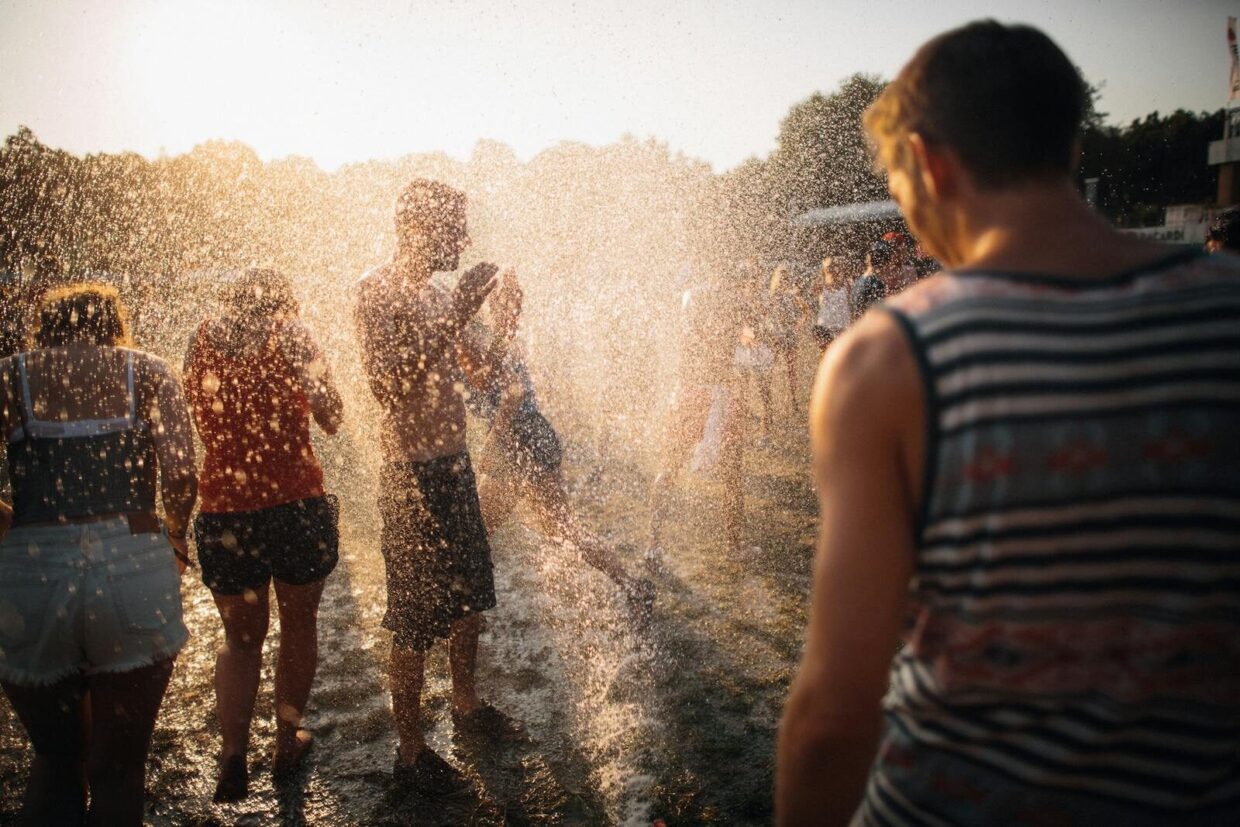 People enjoying water spray at a summer music festival in Budapest, Hungary.