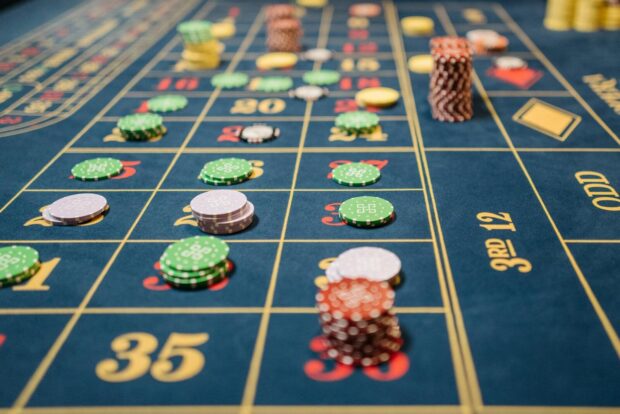 Close-up of a roulette table with colorful poker chips, capturing the thrill of casino gambling.
