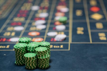 Stack of green poker chips on a casino table, highlighting the gambling theme.