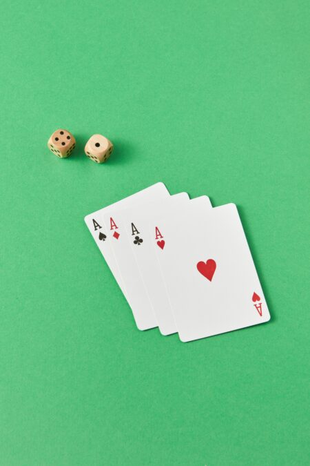 Four aces and dice arranged on green surface, perfect for casino themes.