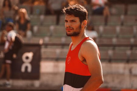 Portrait of a determined male athlete in a sports setting, capturing focused expression and athletic attire.