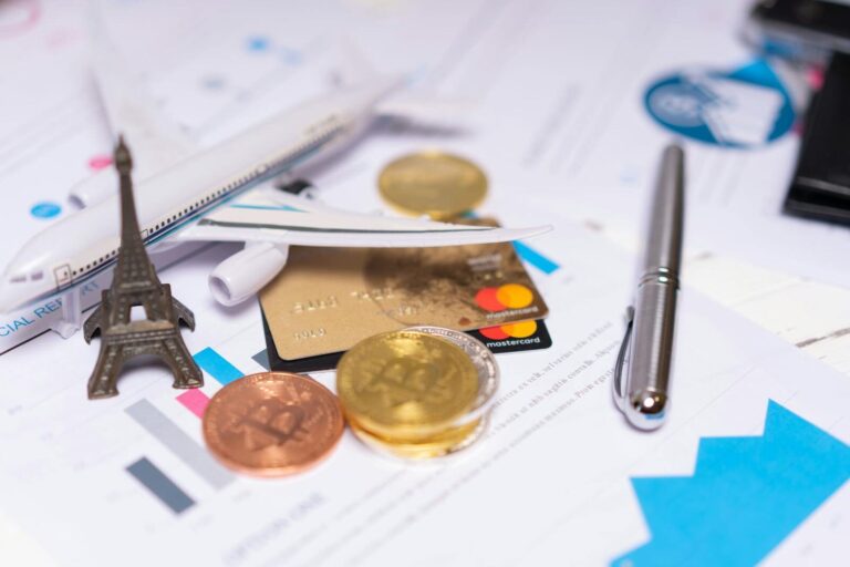 L’économie du tourisme en France vient de poser un record historique A travel finance concept featuring cryptocurrency, credit card, airplane model, and Eiffel Tower on financial documents.