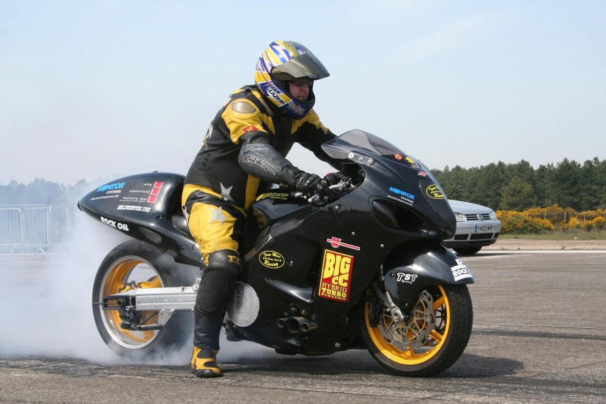Motorcyclist performing an exciting burnout stunt on track at Woodbridge, capturing speed and adrenaline.