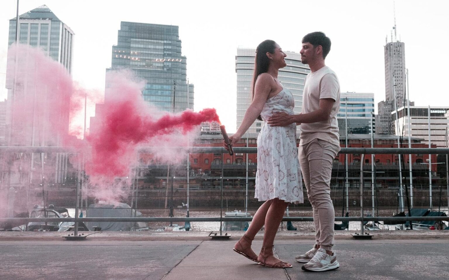 Ghosting, breadcrumbing, love bombing : décrypter les nouvelles pratiques toxiques A couple embraces with a vibrant red smoke bomb in Buenos Aires, creating a romantic urban scene.