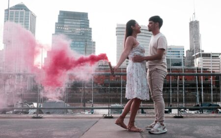 Ghosting, breadcrumbing, love bombing : décrypter les nouvelles pratiques toxiques A couple embraces with a vibrant red smoke bomb in Buenos Aires, creating a romantic urban scene.