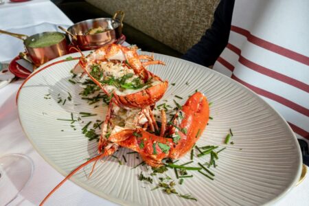 A luxurious lobster meal beautifully presented in a stylish French restaurant.