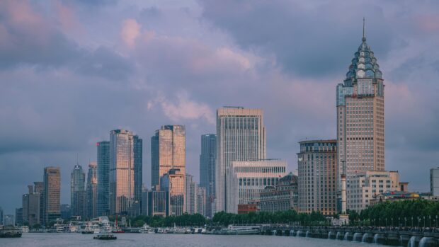 Explorer Pékin et Shanghai : Guide pratique pour les voyageurs français View of Shanghai's modern skyline at twilight with tall skyscrapers and vibrant clouds.