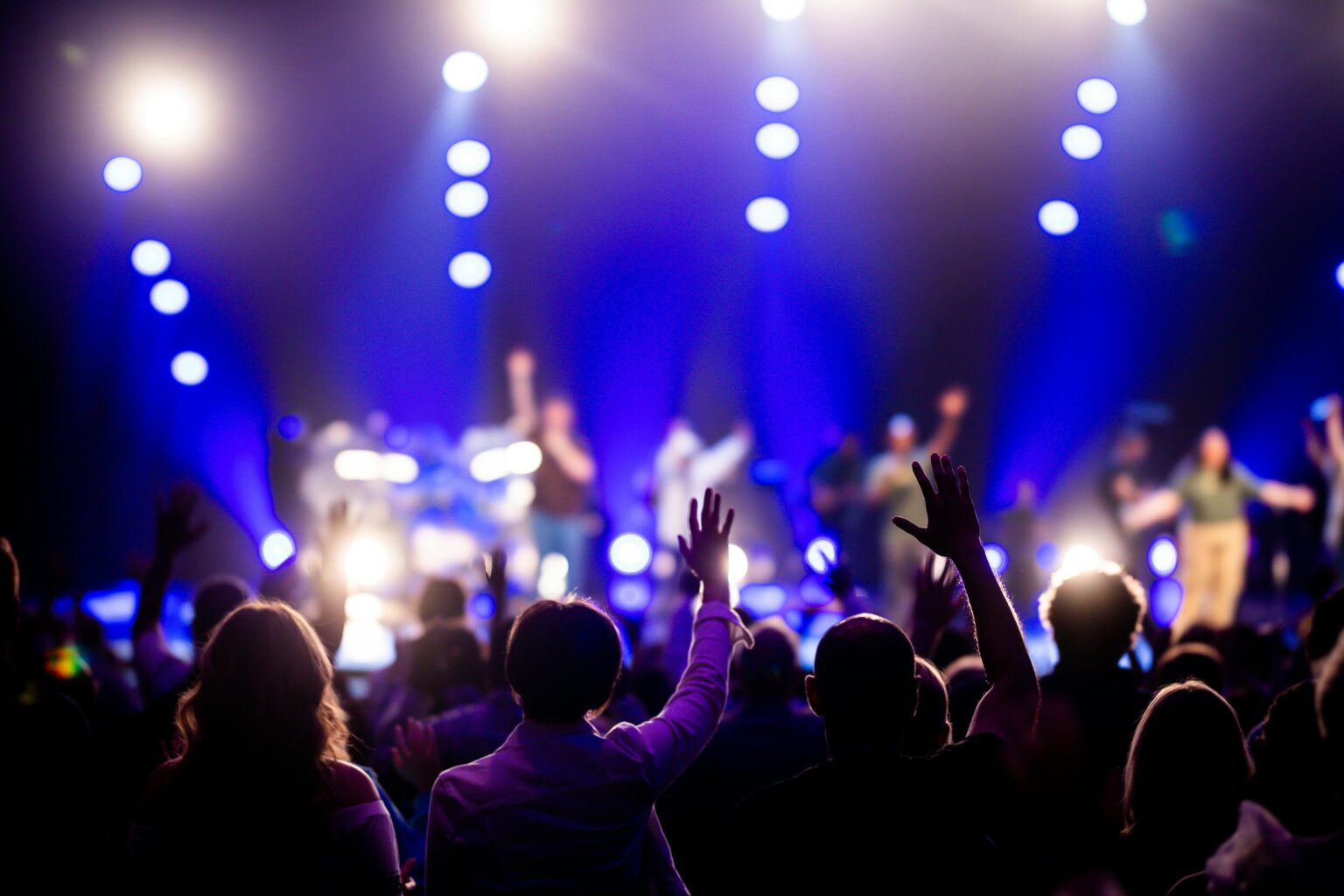 Inflation, abonnements en hausse, droits de douane : le divertissement va morfler en 2026 A vibrant concert scene with an engaged audience enjoying live music under dramatic lighting.