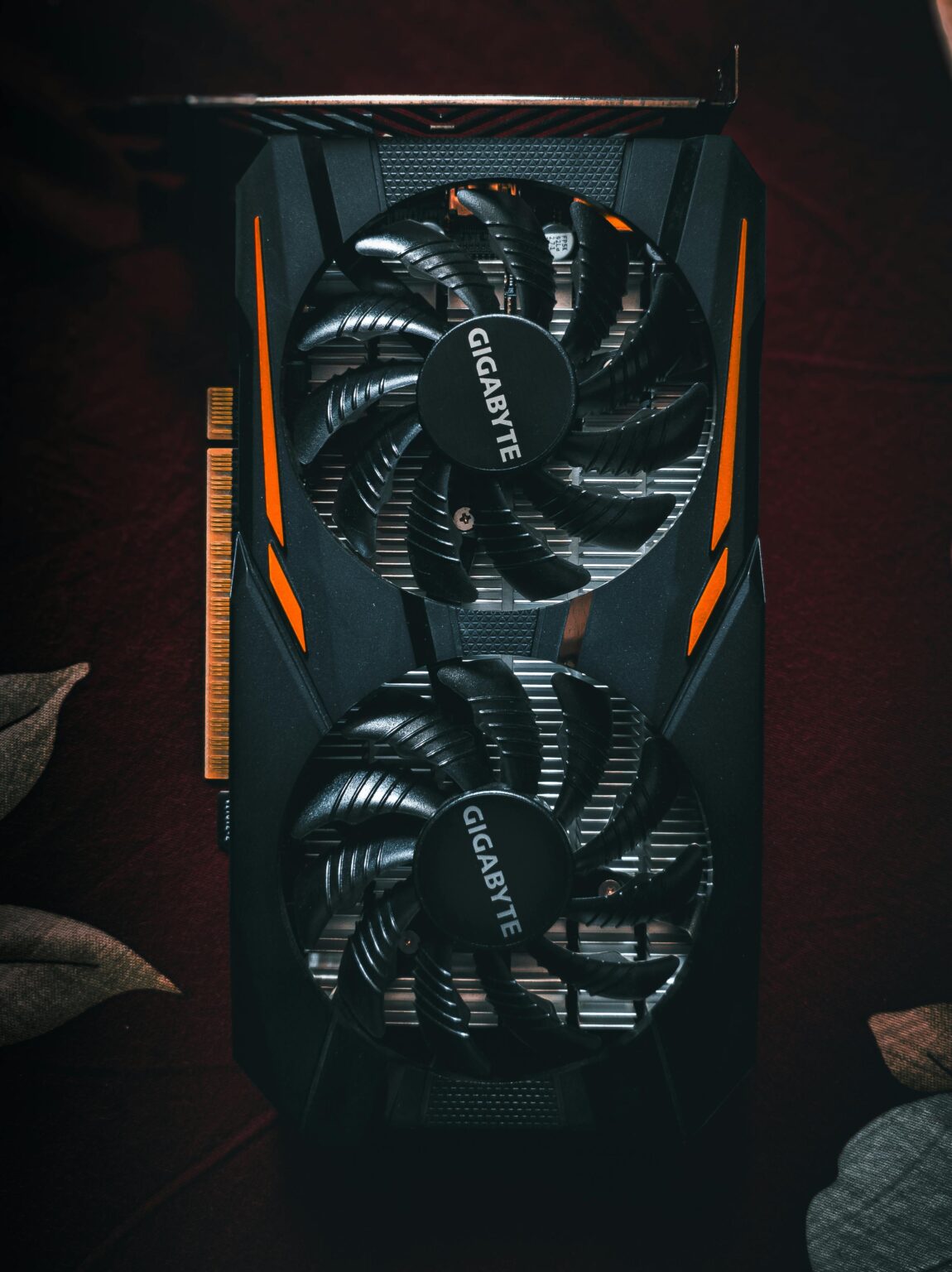 Detailed close-up of a black and orange graphic card with cooling fans.