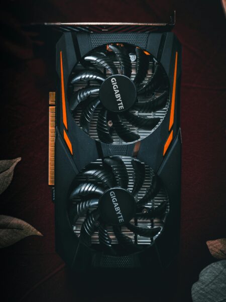 Detailed close-up of a black and orange graphic card with cooling fans.