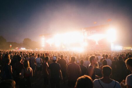 A lively music festival in Budapest with a large crowd enjoying bright stage lights at night.