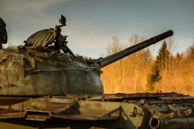Les meilleurs films de guerre basés sur une histoire vraie A rusted tank set against a forest background in Bosnia, highlighting historic military remnants.