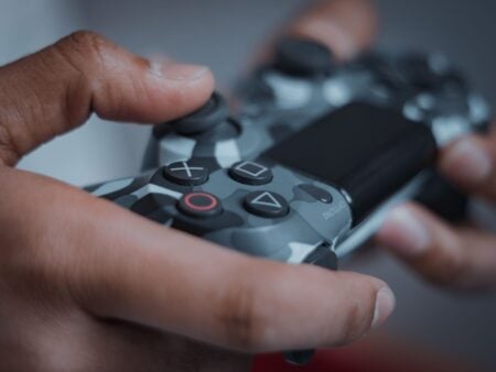 Detailed shot of hands gripping a camouflage game controller, perfect for gaming themes.