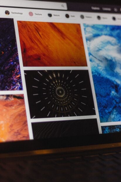 Portable computer with website representing assorted abstract photos under favorites and browser search engine with magnifier symbol