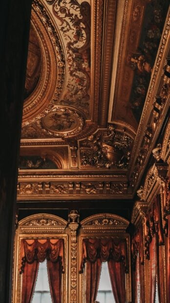 Intricate gold-lined ceiling of Dolmabahçe Palace in Istanbul, showcasing opulent design.