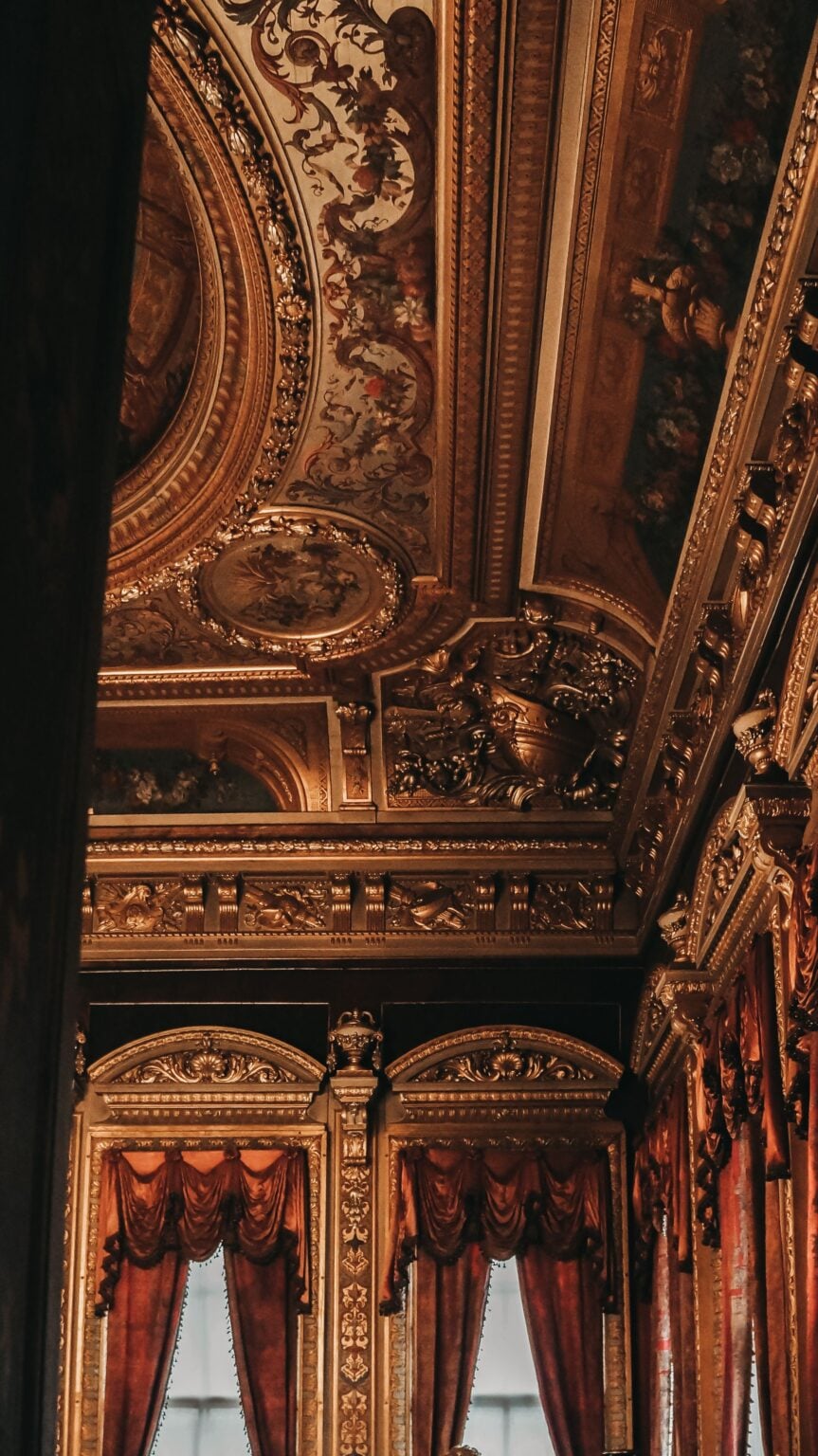 Intricate gold-lined ceiling of Dolmabahçe Palace in Istanbul, showcasing opulent design.