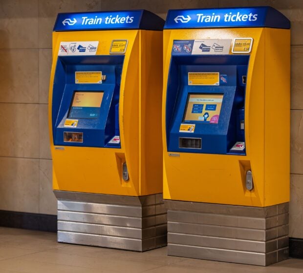 Vente flash SNCF : 100 000 billets TGV Inoui à 19 € pour août 2026 Two vibrant yellow and blue train ticket machines in an indoor station setting.