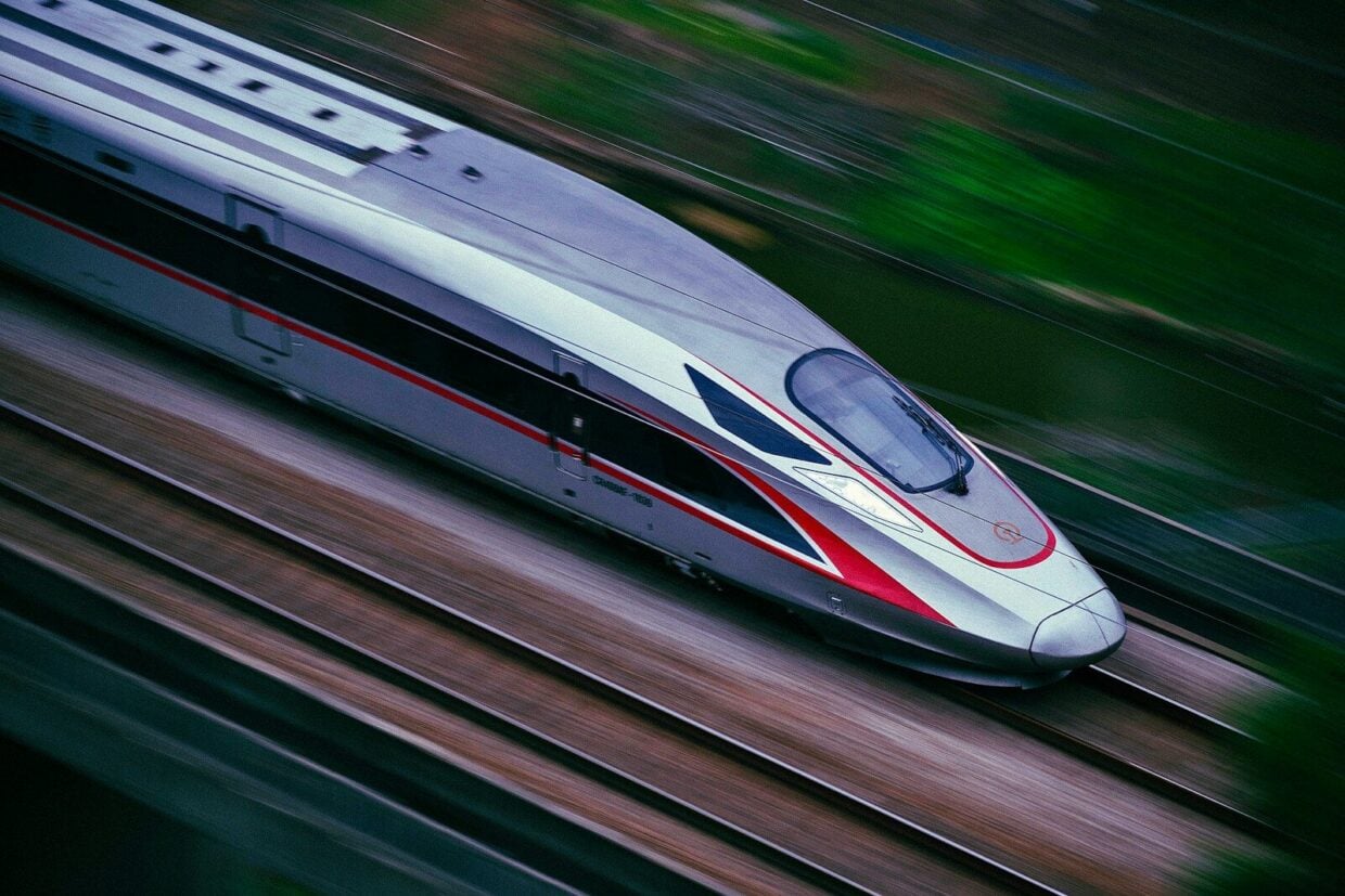 a silver and red train traveling down train tracks