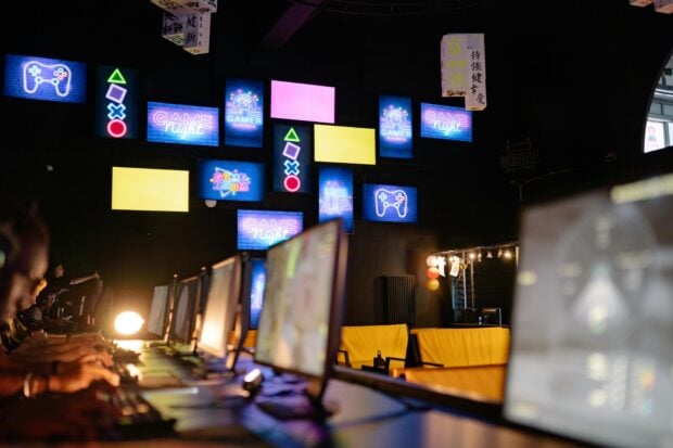 GTA 6, Wolverine, Fable : les jeux vidéo les plus attendus du second semestre 2026 (PS5, Xbox, PC) Illuminated gaming room with colorful screens and neon signs, creating an immersive gaming experience.