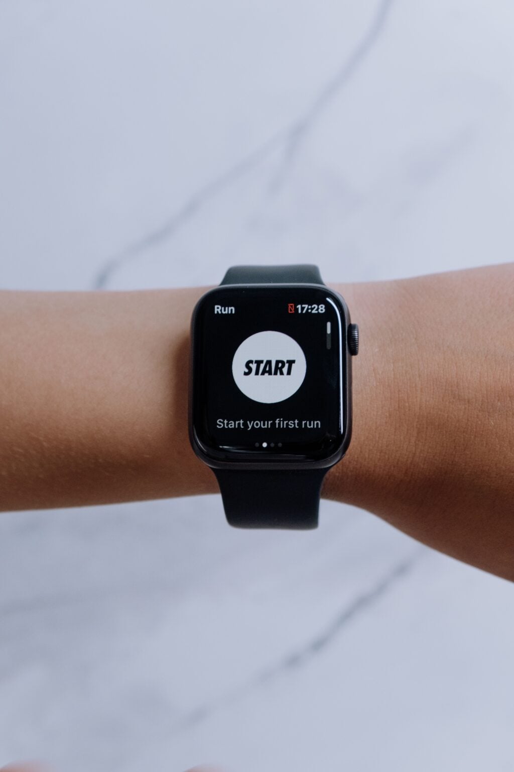 Apple Watch : la montre qui est devenu un accessoire de mode à part entière Close-up of a smartwatch showing a running app on a marble background.