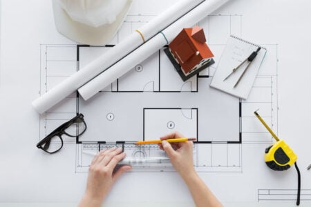 close up of hands with ruler measuring blueprint