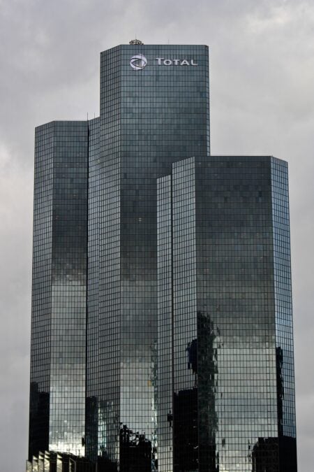 Tall modern skyscraper with reflective windows in La Défense business district, France.