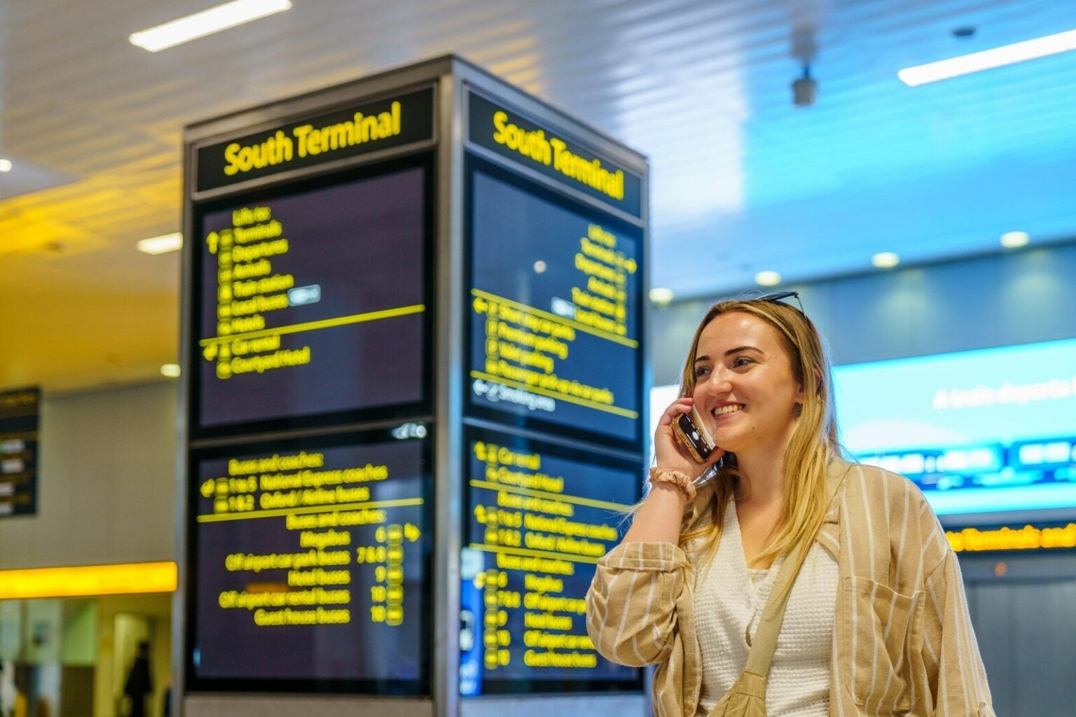 Free Max : le forfait “illimité partout” pour voyager, vrai bon plan ou premium qui se la raconte ? Woman talking on phone near south terminal departure board
