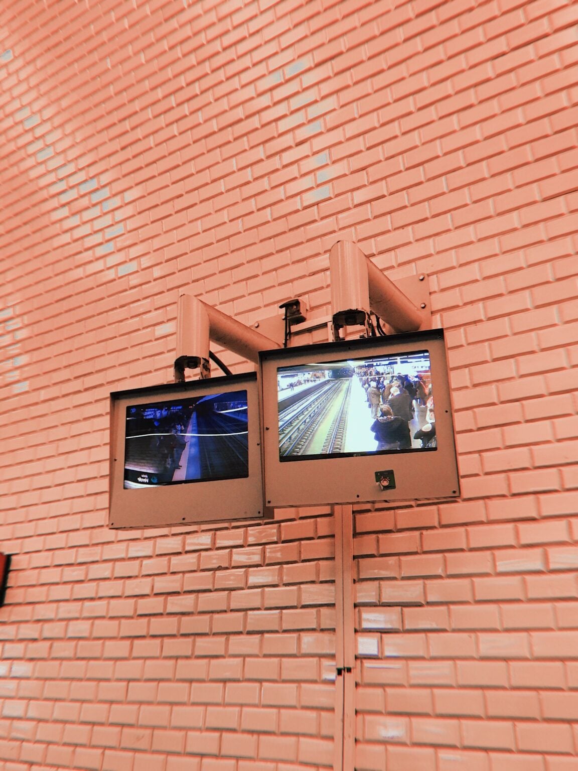 Chat Control : l’UE ressuscite sa surveillance de masse le 9 juillet 2026, et personne n’a vraiment voté pour Dual monitors on a brick wall display subway surveillance footage.