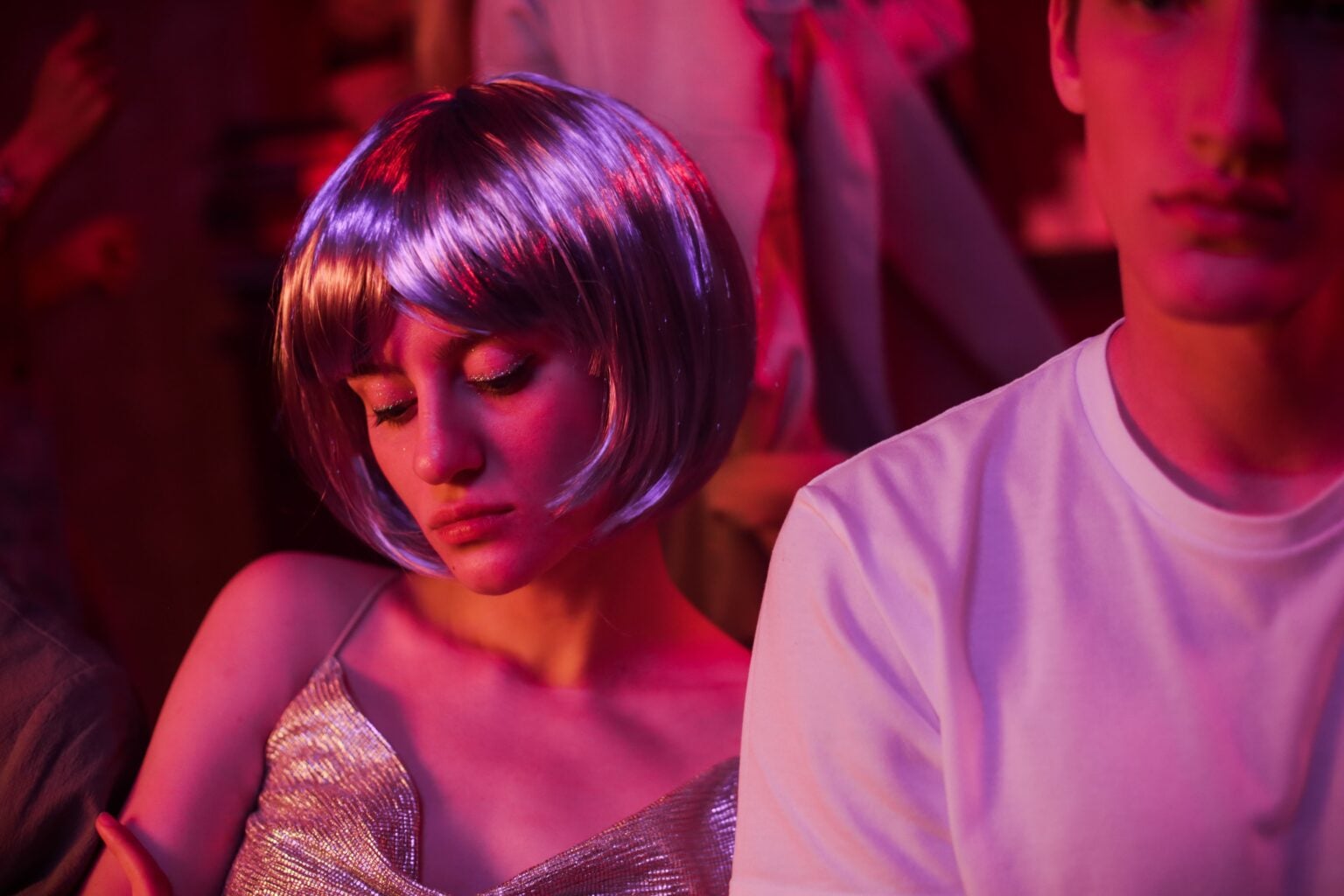 Comment draguer en boîte de nuit : mes meilleurs conseils A young couple enjoying a neon-lit party with vibrant lights.