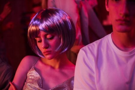 Comment draguer en boîte de nuit : mes meilleurs conseils A young couple enjoying a neon-lit party with vibrant lights.