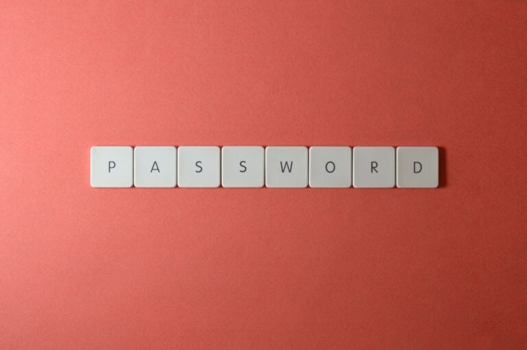 Gestionnaire de mot de passe : pourquoi 94% se font piéger et comment y échapper Focus on password security with white keyboard tiles spelling 'PASSWORD' on a coral background.