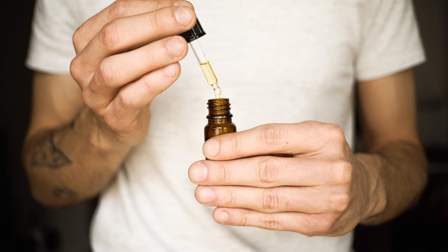 Meilleurs grossistes CBD en France : notre sélection en 2026 a man holding a small bottle with a dropper in it