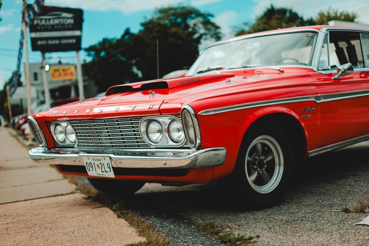 A vibrant red Plymouth Savoy classic car photographed on a sunny day outdoors.
