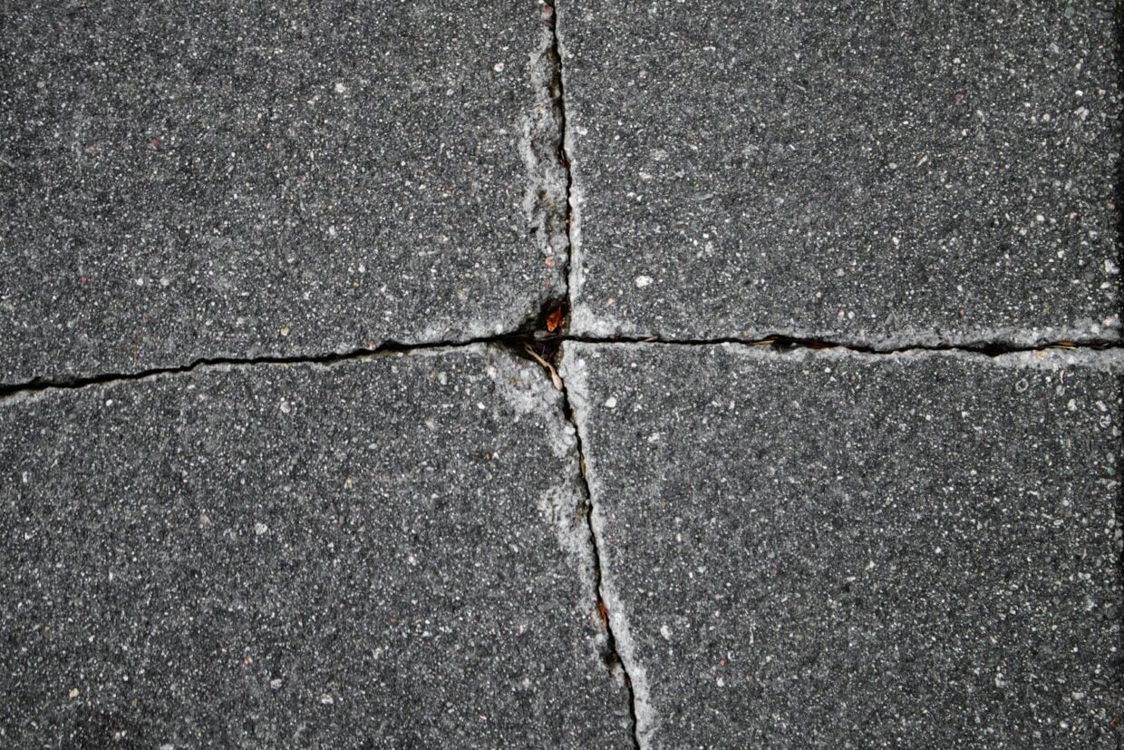 Cracked paving stones show a cross pattern.