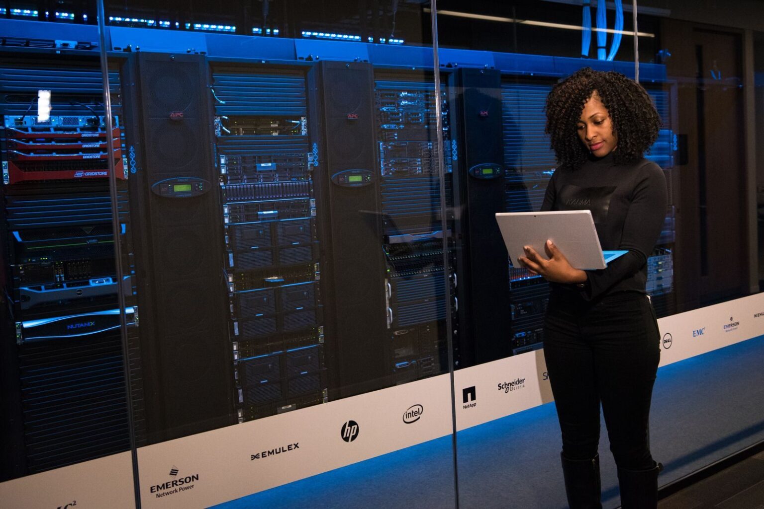 Cloud computing : la prochaine ère de l’innovation numérique A female engineer using a laptop while monitoring data servers in a modern server room.