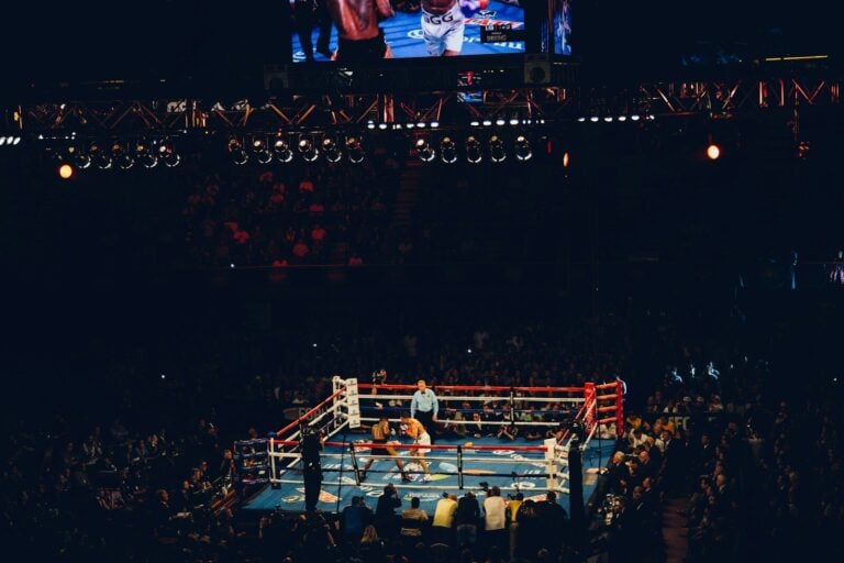 Two boxers sparring in a ring at a crowded arena in Inglewood