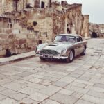 an old car parked on a cobblestone street